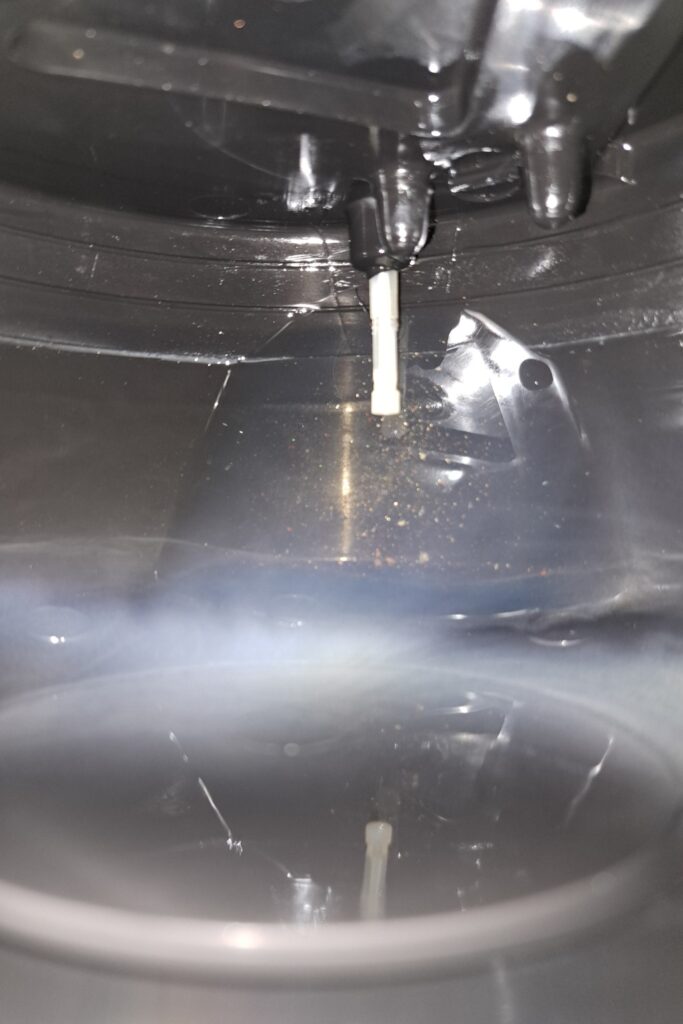 Pohled do útrob nádrže mého VeloSolexu S2200 po návratu z testovací jízdy. Nádrž je vyjetá doslova do poslední kapky a na snímku je vidět čisté dno i originální sací trubička palivového systému.