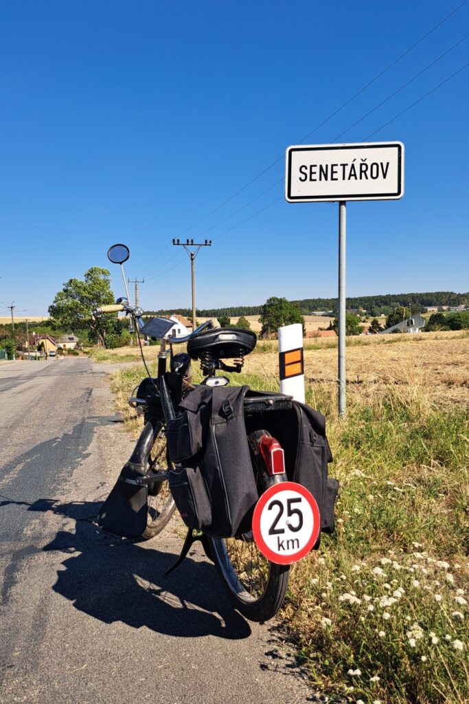 Historický moped VeloSolex S2200 zaparkovaný u dopravní značky obce Senetářov.