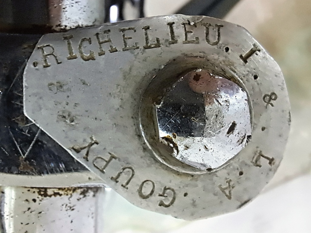 Detailní pohled na starou hliníkovou plaketu pod hlavním šroubem představce mopedu VeloSolex s vyraženými historickými nápisy RICHELIEU a GOUPY.